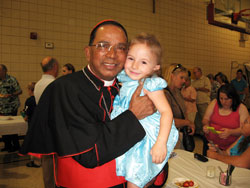 Cardinal Telesphore P. Toppo, Archbisop of Ranchi, India, holds Sophia Gallucci, whom he baptized two years ago on another visit to the United States. Sophia is the daughter of Frank and Tina Gallucci of St. Patrick Parish, Arcola.