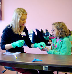 Elizabeth Clawson hands an unconsecrated host to Rebekah Grider. The nine-year-old was born with Pierre Robin Sequence which causes her difficulties in chewing food. For the past eight weeks, she has been receiving treatment at the Feeding Clinic at St. Mary's Hospital in Evansville. Part of the treatment has included preparing Rebekah for her First Communion later this spring at her home parish in Pocahontas, Ark. Elizabeth is a licensed clinical psychologist with the feeding program. (Message photo by Mary Ann Hughes)