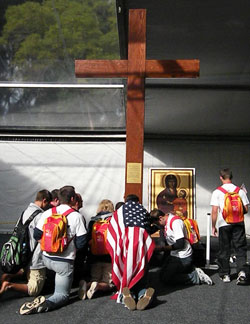Youth praying before the World Youth Day Cross