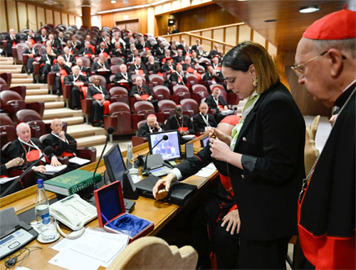 In the presence of members of the College of Cardinals in the New Synod Hall at the Vatican May 6, 2025, a woman defaces the papal fisherman's ring and the lead seal that had marked Pope Francis' letters. (CNS photo/Vatican Media)