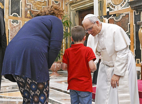 Pope Leo XIV greets a child during an audience with members of the De La Salle Christian Brothers at the Vatican May 15, 2025. (CNS photo/Vatican Media)