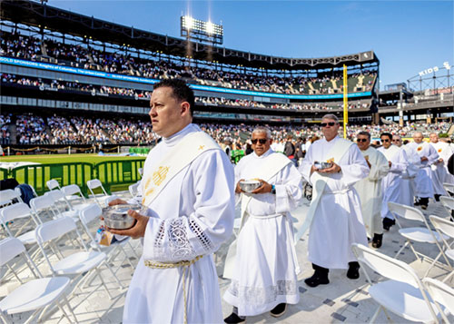 Clergymen arrive to distribute Communion during a June 14, 2025, Mass in honor of Pope Leo XIV at Rate Field in Chicago, home of the Chicago White Sox baseball team. The Chicago-born pontiff, elected May 8, is the first American-born pope in history. (OSV News photo/Carlos Osorio, Reuters)