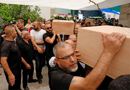 Men carry caskets during the funeral of Manar Khatib and her two daughters, Hala, 20, and Shada, 13, and their relative, Manar Khatib, in Tamra, Israel, June 17, 2025. They were all killed during a missile attack from Iran. (OSV News photo/Ammar Awad, Reuters)