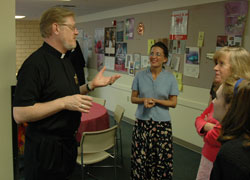 A priest talks with Catholic Center staff